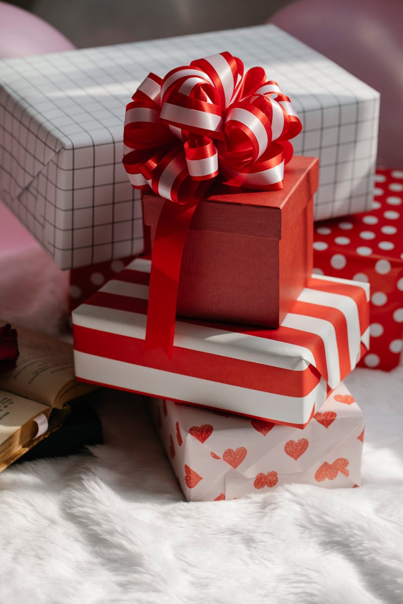A stack of colorful gift boxes with vibrant red ribbons perfect for celebrations.
